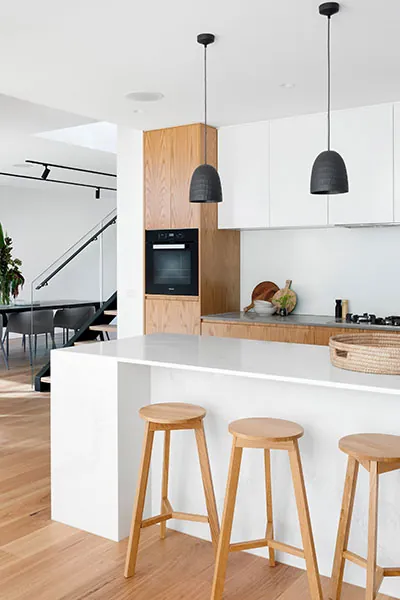 Contemporary open-plan kitchen with pendant lighting designed by The Omega Group